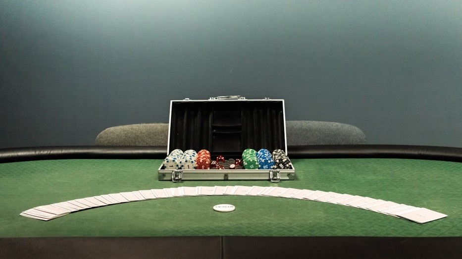 A poker table with a case full of poker chips and cardsDescription automatically generated